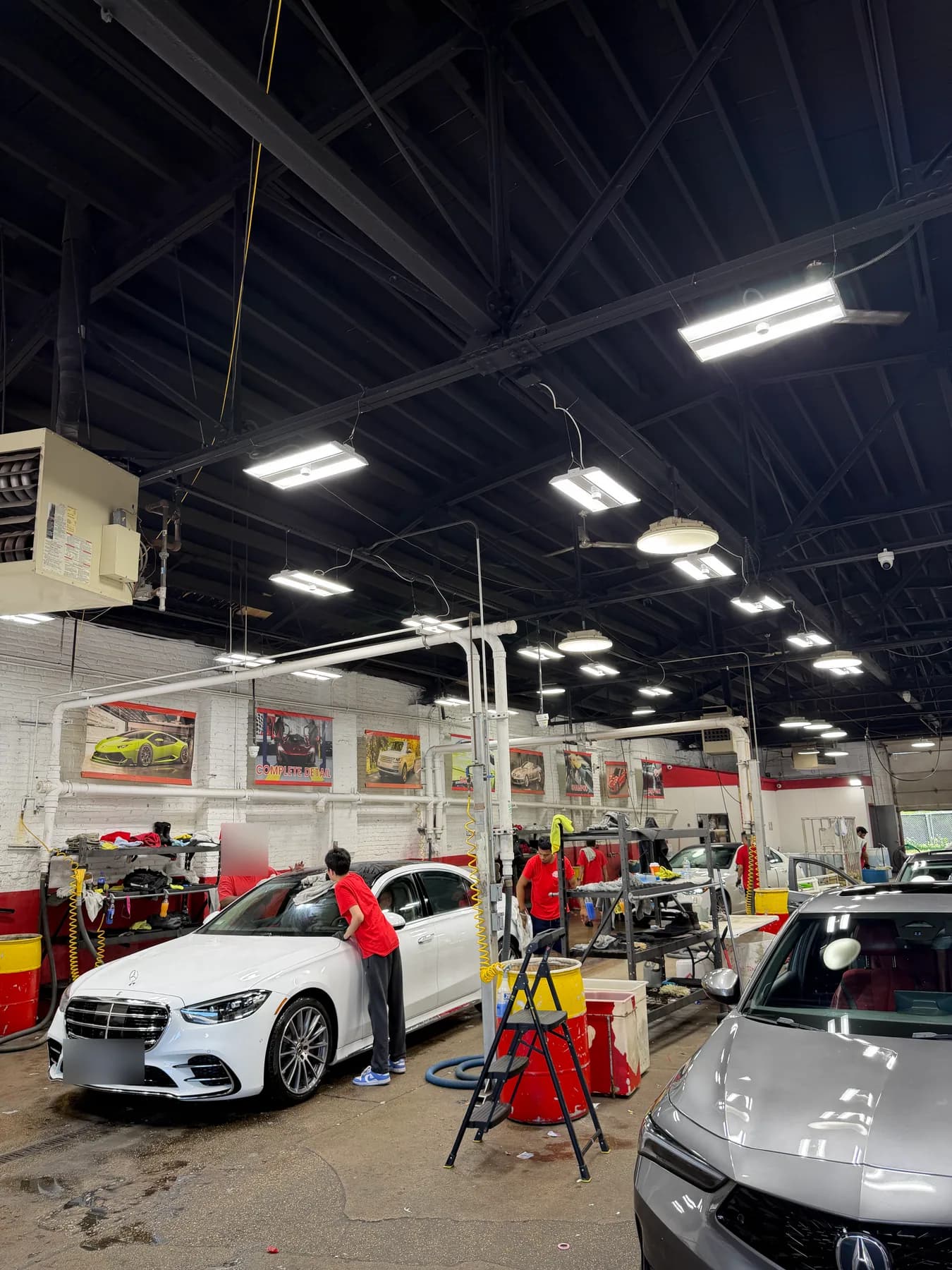 Cars being washed by hand inside the State Street Hand Car Wash service bay