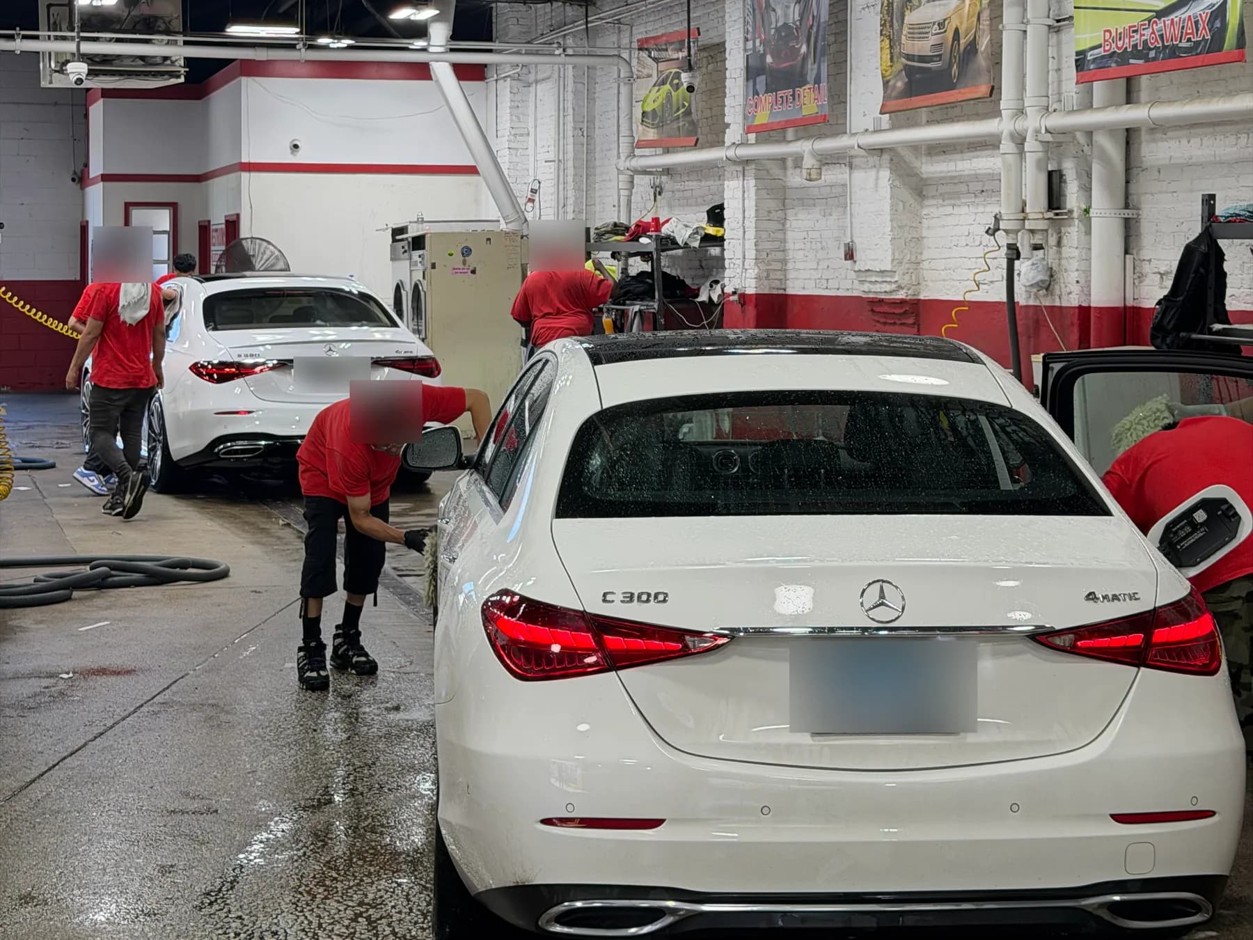 A white sedan being hand finished at the end of the wash line